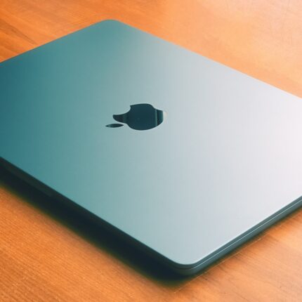 MacBook Air coloris minuit fermé posé sur une table en bois
