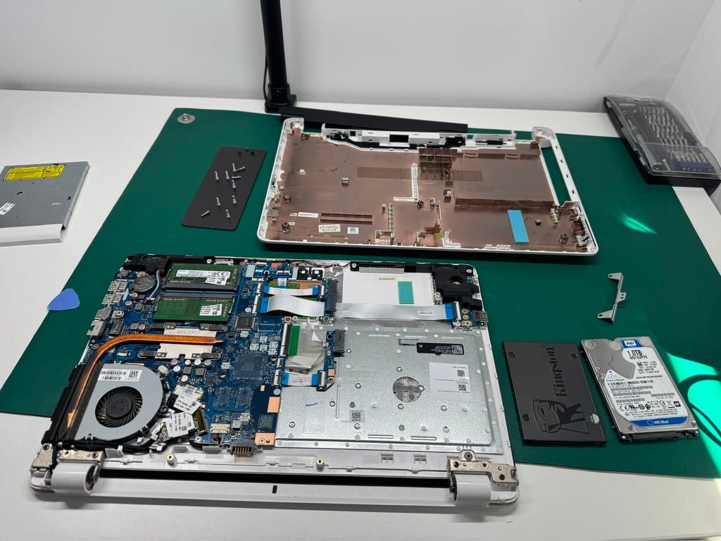 PC portable ouvert à l’atelier, SSD Kingston à côté de l’ancien disque dur WD 1 To